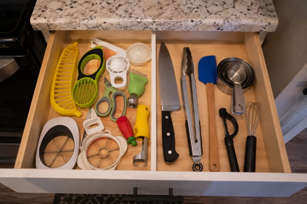 Unnecessary kitchen gadgets mixed with useful basic tools in a kitchen drawer